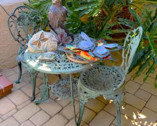 This table and chair set is supporting decorative butterflies and a rather large...hawk?  Quail?  It is probably used to deter other birds.