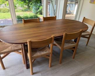 $2,600 Dining table and six chairs. Sundays Furniture dining table measures 86" l X 39"w X 29"h. Chairs are 18.5"w X 18"d X 32.5"h. House of Leon wood with woven seats. One chair "as found". (Orig. $5,300)