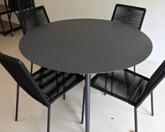 $960. Article metal "Ballo" dining table and four "Zina" stackable chairs chairs. 47 inch diameter by 29 inches high. Originally