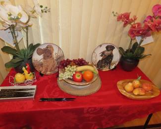 Plates, silk orchids, plastic fruit and stone fruit.