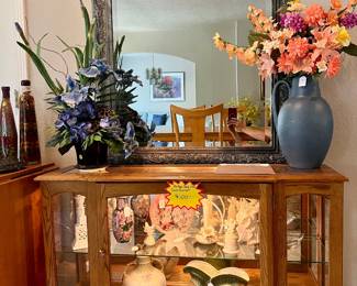 vintage solid oak Curio cabinet with antiques and a large decorative wall mirror