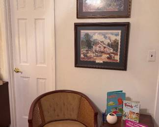 Upholstered accent chair, wood nesting tables, framed wall art, children’s books, and decorative home accents