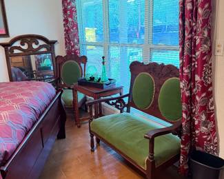 Antique carved wood bedroom furniture, upholstered green Victorian-style loveseat and accent chairs, side table, floral drapes, bedroom décor, and home furnishings