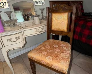 Antique white vanity with mid-century modern wooden chair on casters