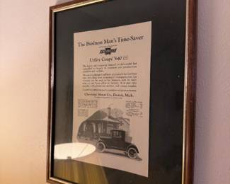 Framed vintage newspaper advertisement featuring a classic automobile