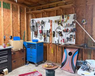 Workshop loaded with hand tools, wall-mounted tool storage, workbench, rolling tool chest, hardware, and garage essentials