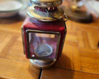 Vintage Red Metal Candle Lantern with Glass Panels  Charming vintage red metal candle lantern featuring four glass panels, a vented brass-tone top, and a classic railroad/carriage design. Perfect for farmhouse, rustic, cabin, or country décor. This decorative lantern makes a wonderful display piece for collectors or anyone looking to add vintage character to their home.  Manufacturer: Unknown (maker's mark not visible) Approximate Year: 1960s–1980s Material: Painted metal, glass, and brass-tone metal Color: Red with brass-tone accents Condition: Good vintage condition with age-related patina and wear consistent with use. Glass appears intact. Please review all photos for condition. Suggested Estate Sale Value  $30 Collector (if complete and in excellent condition) Shipping  Buyer pays actual shipping. Local pickup is also available.
