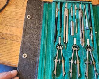 Description: Vintage drafting and engineering instrument set complete with multiple precision compasses, dividers, ruling pen, extension bars, lead holder, and accessories in the original fitted carrying case. This professional-quality drafting set was designed for architects, engineers, surveyors, and technical illustrators before the CAD era. The instruments appear to be in good vintage condition with normal signs of age and use. Great addition for collectors, display, restoration, or anyone interested in vintage drafting tools.  Manufacturer: Unknown (markings not visible) Approximate Year: Circa 1950s–1970s Condition: Good vintage condition with original case; appears substantially complete. Includes: Original fitted case with multiple drafting instruments and accessories.  Suggested Estate Sale Price:  Quick Sale: $30–40