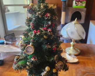Lighted Christmas Tree Holiday Decoration  Price: $35  Decorative lighted Christmas tree with ornaments, star topper, and illuminated winter village base. A beautiful tabletop holiday decoration.  Condition: Good vintage condition with light wear. Includes power adapter. Sold as found; see photos.  Estimated Value:  Estate Sale: $35 Online: $45–70 Antique Shop: $65–90  Buyer pays shipping or local pickup available.