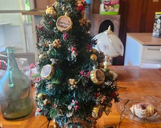 Lighted Christmas Tree Holiday Decoration  Price: $35  Decorative lighted Christmas tree with ornaments, star topper, and illuminated winter village base. A beautiful tabletop holiday decoration.  Condition: Good vintage condition with light wear. Includes power adapter. Sold as found; see photos.  Estimated Value:  Estate Sale: $35 Online: $45–70 Antique Shop: $65–90  Buyer pays shipping or local pickup available.