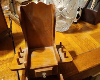 This appears to be a wooden desktop organizer or gentleman's valet, not an antique.  Features I notice:  Small center drawer for cufflinks, coins, or jewelry. Pegs on each side for rings, watches, or keys. Curved sides and solid wood construction. Likely made between the 1960s and 1980s. Estimated Value Garage sale: $5–10 Estate sale: $10–20