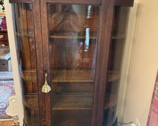 Oak bow front china cabinet with beveled mirror on top