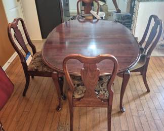 Dining table with 5 chairs 1 leaves, an additional chair has a broken arm.