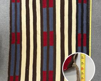 Vintage Diné Navajo second phase chief's blanket, characterized by traditional dark-and-light banded stripes accented with rectangular blocks of blue and red; approximately 63" long.