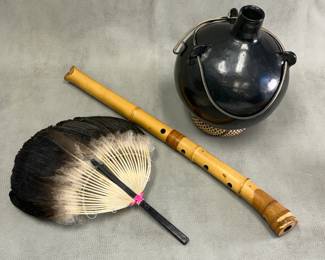 A Santa Clara pueblo black ware round canteen vessel with three handles and leather strap; a feather fan; and a Japanese bamboo Shakuhachi flute 