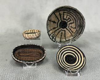 A Tahons O'odham miniature basket, yucca and devil's claw plant fibers, 3-1/4" wide; Native American Tohono O'odham miniature coiled woven plaque yucca and devil's claw plant fibers, 2" wide; Native American miniature oval shape woven pine needle basket, 2-1/2" long; and a miniature hand-woven basket, 1-1/2" wide