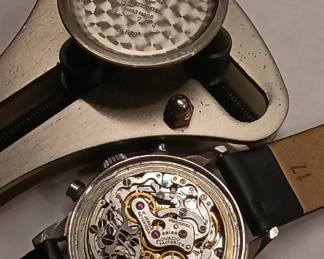 Closeup view of the 1950s-60s vintage Movado M95 "SUB-SEA" Chronograph wrist watch with black leather strap, in the original box. This watch has Movado Factories Swiss in-house Calibre M95 - a 17-jewel, manual-wind, column-wheel chronograph movement developed in partnership with Frédéric Piguet. Case is stainless steel, Fabrique de Boîtiers (FB) / François Borgel. Screw-down caseback stamped with Movado crown, case no. 2496, ref. 95.704.568 with "SUB-SEA" engraved on the case band.