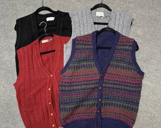 Variety of men's v-neck knit wool sweater vests in black, red, grey; and one multicolored Fair Isle Shetland wool knit pattern in burgundy, green, and navy blue, with leather wrapped buttons