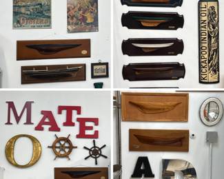 A collection of vintage wooden half-hull boat model plaques mounted on dark wooden backboards with brass nameplates; vintage advertising signs including a wooden wall plaque or sign shaped like a bottle of Kickapoo Indian Oil, a 19th-century "cure-all" patent medicine