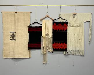 A Fulani People man’s tunic, Mali/Niger Bend, sheep's wool woven in four separate panels with centered geometric embroidered motif; two vintage North American Native Navajo (Diné) woven Biil dress panels in black with finely rendered red geometric patterns, one woven by Anna Clyde; three classic Native American Hopi Tribe hand-woven cotton “rain” sashes worn in traditional dances; and a traditional Plains-style Native American buckskin or hide dress with fringe details 