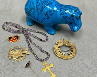 A vintage reproduction of William the Hippo, the iconic turquoise-blue Egyptian faience hippopotamus from the Metropolitan Museum of Art, decorated with painted black lotus flower designs; whimsical stickpins, brooches and beaded necklace