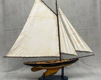 A large, beautiful hand-crafted wooden model of a Newport sloop style sailing vessel, with canvas sails and metal hardware, on wooden stand. Approximately 35 inches tall.