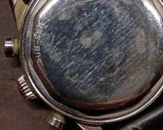 Closeup view of the 1950s-60s vintage Movado M95 "SUB-SEA" Chronograph wrist watch with black leather strap, in the original box. This watch has Movado Factories Swiss in-house Calibre M95 - a 17-jewel, manual-wind, column-wheel chronograph movement developed in partnership with Frédéric Piguet. Case is stainless steel, Fabrique de Boîtiers (FB) / François Borgel. Screw-down caseback stamped with Movado crown, case no. 2496, ref. 95.704.568 with "SUB-SEA" engraved on the case band.