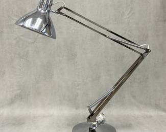 Chrome 1970s Luxo L-1 articulated work light originally invented in 1937 by Norwegian designer, Jac Jacobsen. This mid-century modern classic is famous for its unique cantilevered, spring-balanced arm system, which allows the user to smoothly adjust the height and angle of the light while keeping the lamp head perfectly parallel to the work surface.