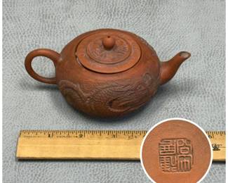 Closer view of the Vintage Chinese Yixing teapots, one in appliqué style with carved dragon curving along the side of the pot; makers mark on the base