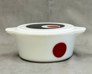 A vintage 1971 Pyrex Moon Deco promotional 2.5 quart casserole dish featuring a bold, mod black and red geometric circle pattern on the white opal glass lid and side