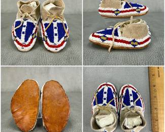 More views of the child’s sized pair of traditional Native American beaded leather moccasins, likely Plains Indian or Lakota Sioux-style; with glass seed beadwork featuring a central vertical white stripe flanked by bold blue fields and red-and-white curved border motifs on soft suede hide. Integrated leather tie laces through the cuff fold.