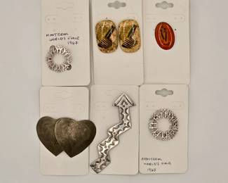 Two silver-tone Expo '67 logo brooches from the 1967 Montreal World's Fair; an oval glazed enamel Mother Mary lapel pin in an orange and yellow tone; a vintage, embossed metal double heart-shaped brooch, and a silver-tone hand-stamped metal Navajo style lightning bolt brooch