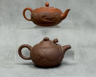 Vintage Chinese Yixing teapots, one in appliqué style with carved dragon curving along the side of the pot, and one "Fish Transforms into Dragon Pot" design with a fish among waves on the side of the pot and articulated dragon's head in the lid beneath a cloud shaped finial; makers marks to base 