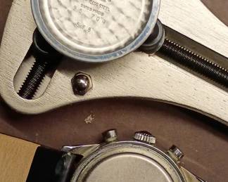 Closeup view of the 1950s-60s vintage Movado M95 "SUB-SEA" Chronograph wrist watch with black leather strap, in the original box. This watch has Movado Factories Swiss in-house Calibre M95 - a 17-jewel, manual-wind, column-wheel chronograph movement developed in partnership with Frédéric Piguet. Case is stainless steel, Fabrique de Boîtiers (FB) / François Borgel. Screw-down caseback stamped with Movado crown, case no. 2496, ref. 95.704.568 with "SUB-SEA" engraved on the case band.
