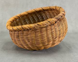 A hand-woven wicker bowl or basket featuring a rounded, bulbous shape and a thick, braided rim; 7"W x 4-3/4"H