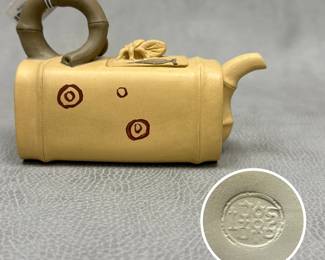A Chinese handcrafted ceramic novelty teapot, resembling a bamboo segment with bamboo-shape loop handle, a bug figurine on the lid, and painted concentric circle accents