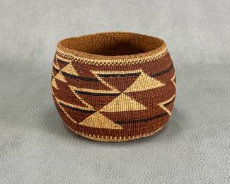 A beautiful Hupa/Yurok/Karuk polychrome basket hand-woven with natural fibers to display traditional geometric motifs in natural brown, tan, and black. Approximately 3-1/2"H x 5" W.
