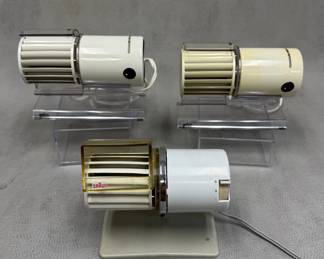 Keep mid-century modern cool with a vintage Braun HL 1 desk fan designed by Reinhold Weiss for Braun AG in 1961, and two vintage Braun HL 70 personal desk fans, all featuring a cream-colored cylindrical plastic body and a clear acrylic stand.