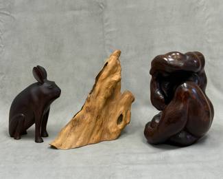 A carved wooden rabbit sculpture, 9 inches tall; an organic wood root sculpture featuring a smooth, polished natural finish with unique hollows and grain patterns; and a hand-carved wooden sculpture of seated female figure, 11 inches tall, with polished dark wood finish with prominent natural grain patterns