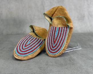 Pair of vintage Native American beaded leather moccasins, Cree Indian beaded moccasins circa 1930-40, featuring intricate glass seed beadwork in striking turquoise and red vertical linear patterns with a delicate blue and green bead edging along the collar
