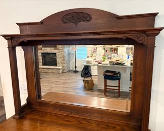 antique oak overmantel mirror resembles designs from the late 19th-century Victorian or Edwardian eras, used on sideboard