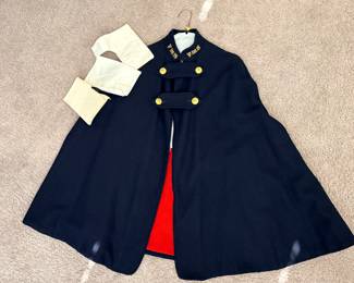 1940s WWII-era wool nurse's cape, likely manufactured by Bruck's Nurses' Apparel, featuring a navy blue exterior with a bright red lining and gold-colored buttons