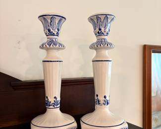 vintage Delftware style ceramic candlestick holders, often featuring iconic cobalt blue floral motifs on a white glaze