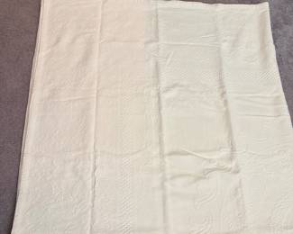 vintage white matelassé or piqué bedspread, featuring intricate woven floral and textured decorative patterns