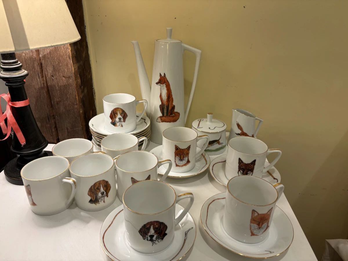 Hand painted hunt themed china coffee/tea service by PF Menzies : 11 saucers with hunt whips, 10 cups with half hounds and half foxes, tall pitcher with lid with fox on one side, hunt whip on the other, lidded sugar bowl with 3 hounds, small cream pitcher with fox and tree and fence on back