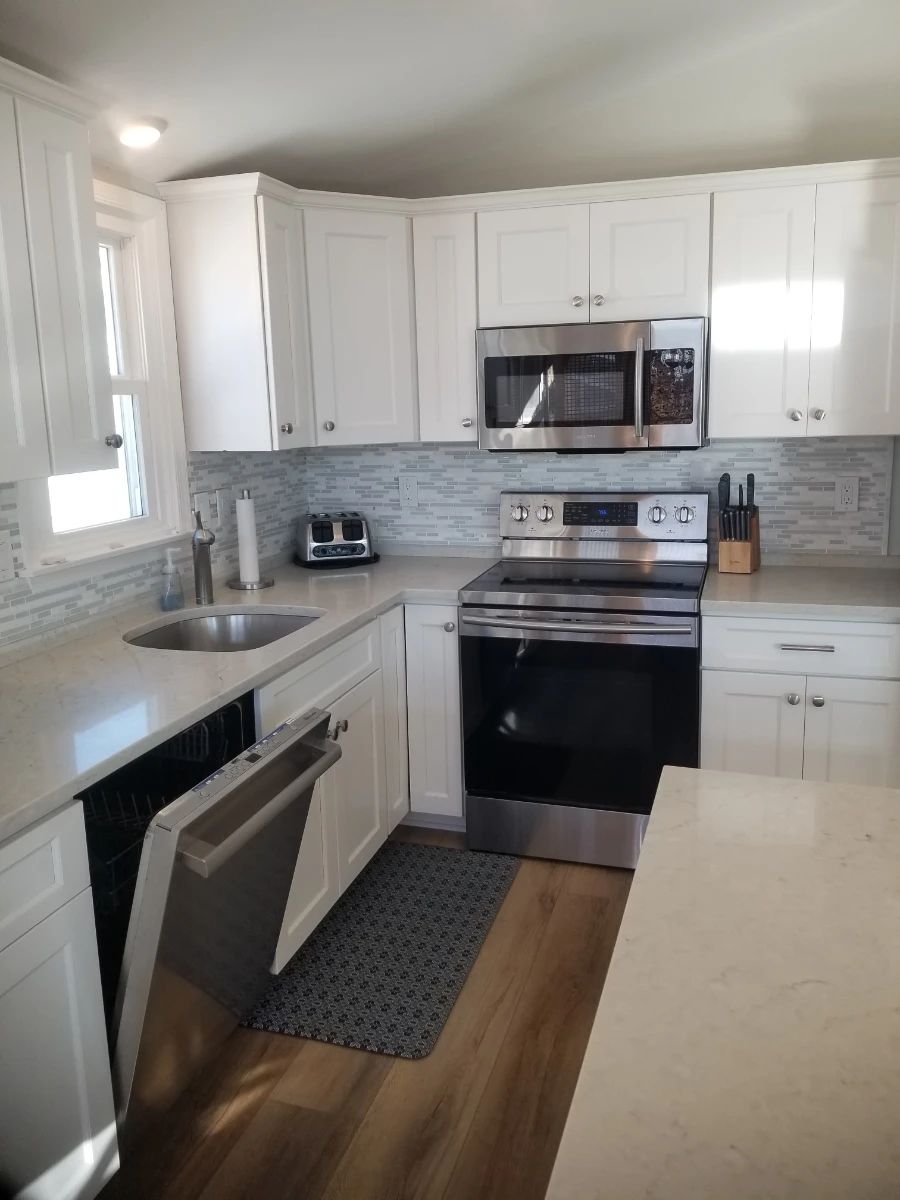 Upper unit L-shaped kitchen with an island - crisp white contemporary cabinetry