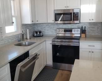 Upper unit L-shaped kitchen with an island - crisp white contemporary cabinetry