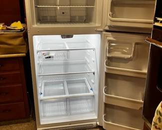 Frigidaire White Top-Freezer Refrigerator. Clean interior, complete with wire freezer shelf, main glass shelving, dual crisper drawers, and full door racks.