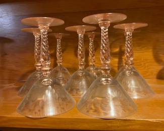 A stunning set of 8 vintage glass cocktail/wine goblets featuring clear floral and wheat/leaf wheel-etched conical bowls paired with intricate pink twisted-rope (barley twist) stems and circular pink bases.