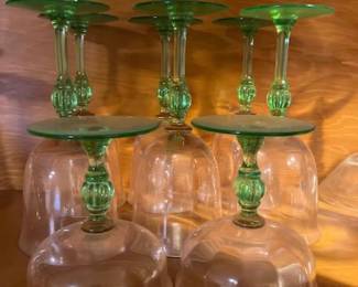A striking set of 8 vintage stemmed glasses featuring clear bowls, vibrant green stems with a distinct ribbed/fluted bulbous knop, and matching green feet. The set includes a mix of tall wine/water goblets and shorter sherbet/champagne coupes sharing the same elegant stem design.